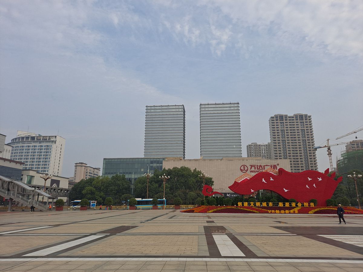The open granite expanse of Bayi (August 1st) Square in central Nanchang, looking north across the paving towards Wanda Plaza and the city's office towers