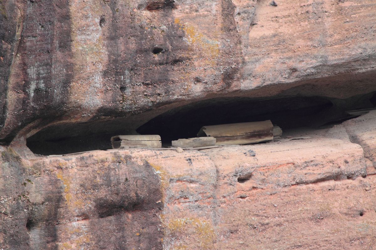 Longhushan's Danxia landform — rust-red sandstone cliffs and rounded domes rising above green water and forest