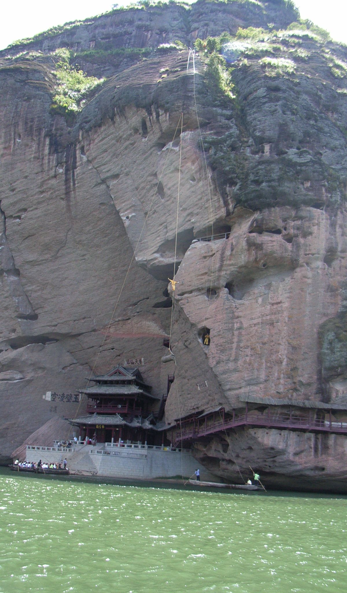 Ancient wooden cliff coffins (hanging coffins) of the Yue people wedged high in the rock face above the Luxi River at Longhushan