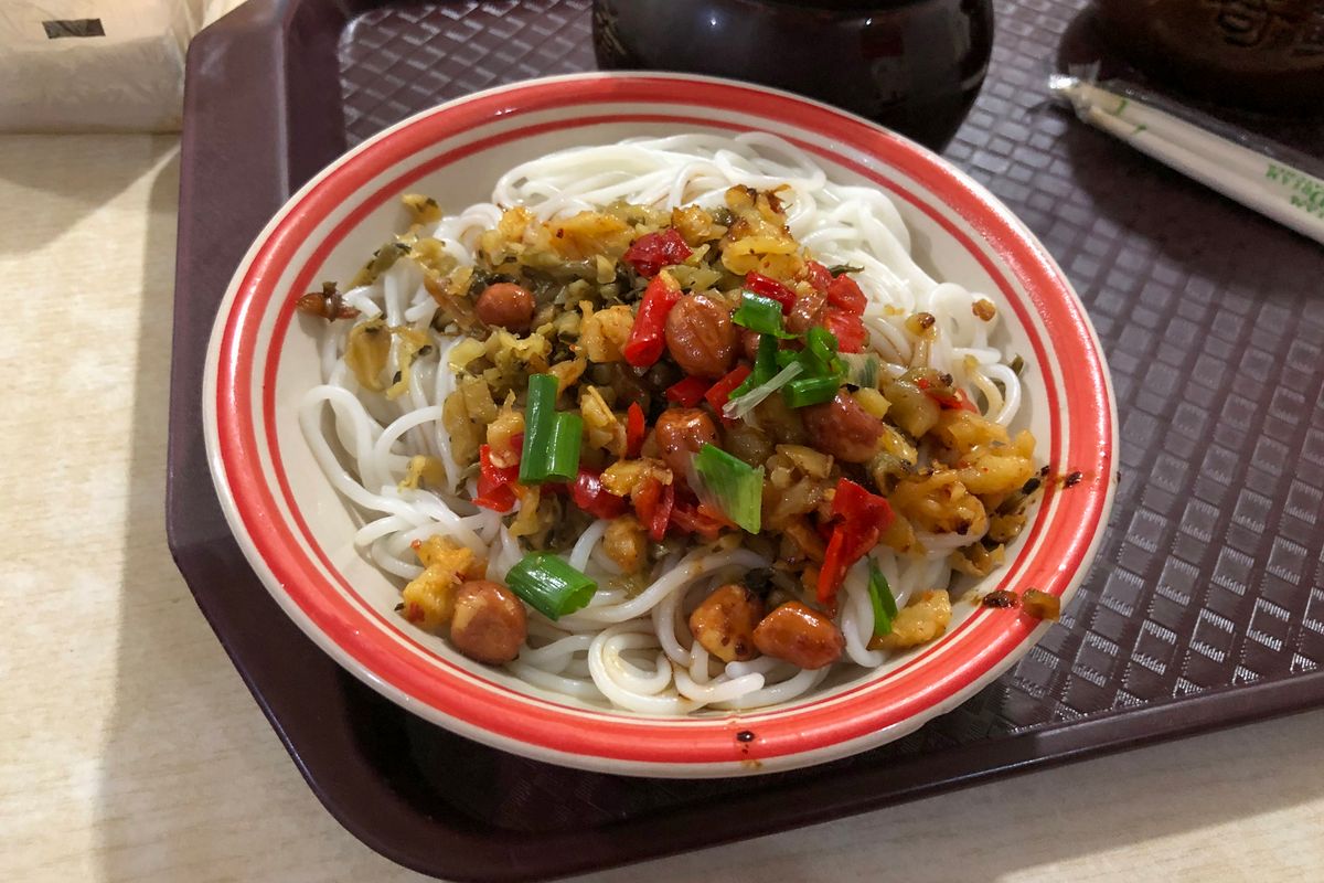 A bowl of Nanchang mixed rice noodles (拌粉), the city's signature breakfast, topped with chilli, pickles and peanuts
