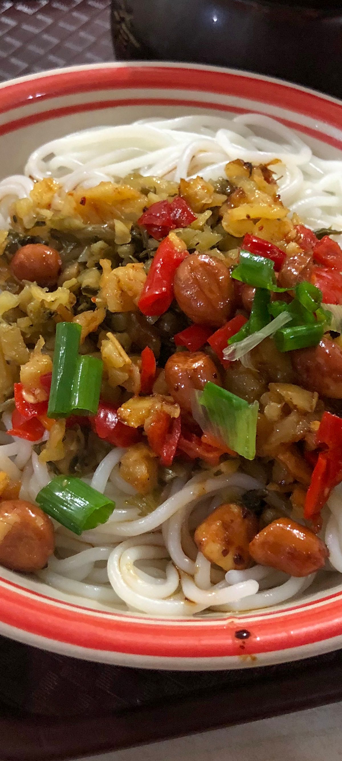 A bowl of Nanchang mixed rice noodles (拌粉), the city's signature breakfast, topped with chilli, pickles and peanuts
