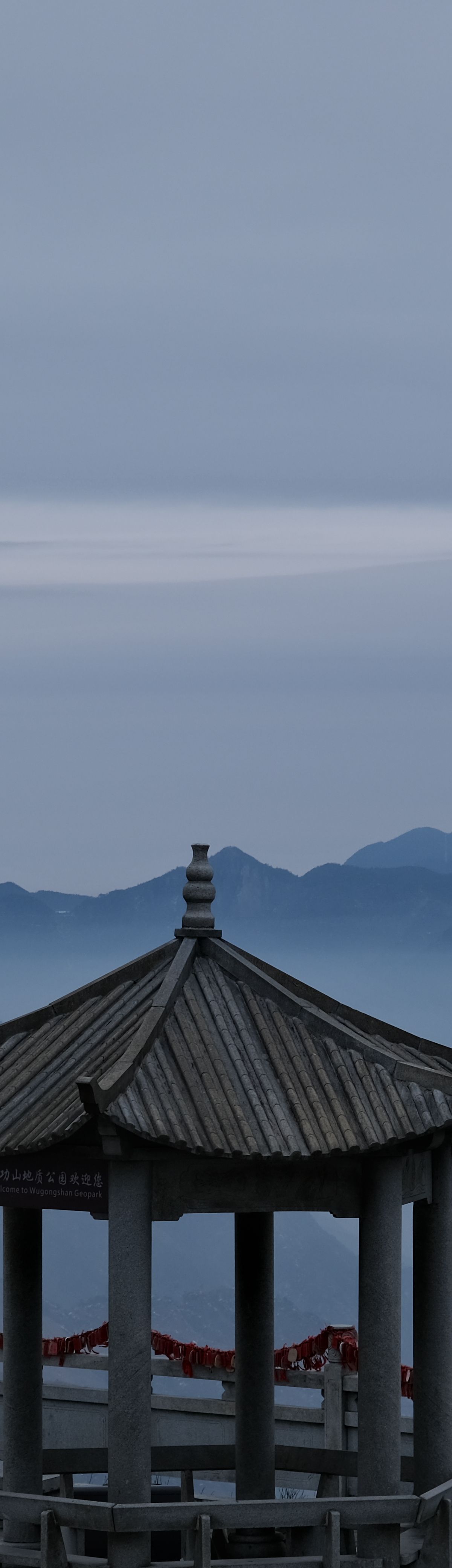A ridge-top pavilion on Wugongshan rising above a sea of clouds at dawn, the classic reward for staying overnight